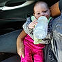 Cataleya participe au concours pour gagner de l'argent avec cette photo : baby, bottle, feeding, infant, car_interior, person, hand, clothing, pink_pants, gray_shirt, seat, door_handle, window_control, socks, holding, closeup, cute, child, casual, indoor