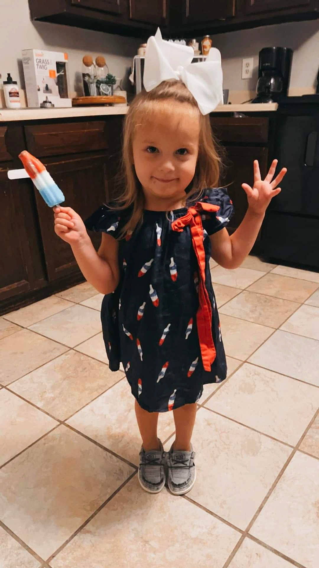Madalynn is registered to the contest to win money with this photo: child, dress, event, fashion_design, finger, flooring, formal_wear, fun, gesture, hair, happy, human_body, human_leg, joint, joy, pattern, person, room, skin, smile
