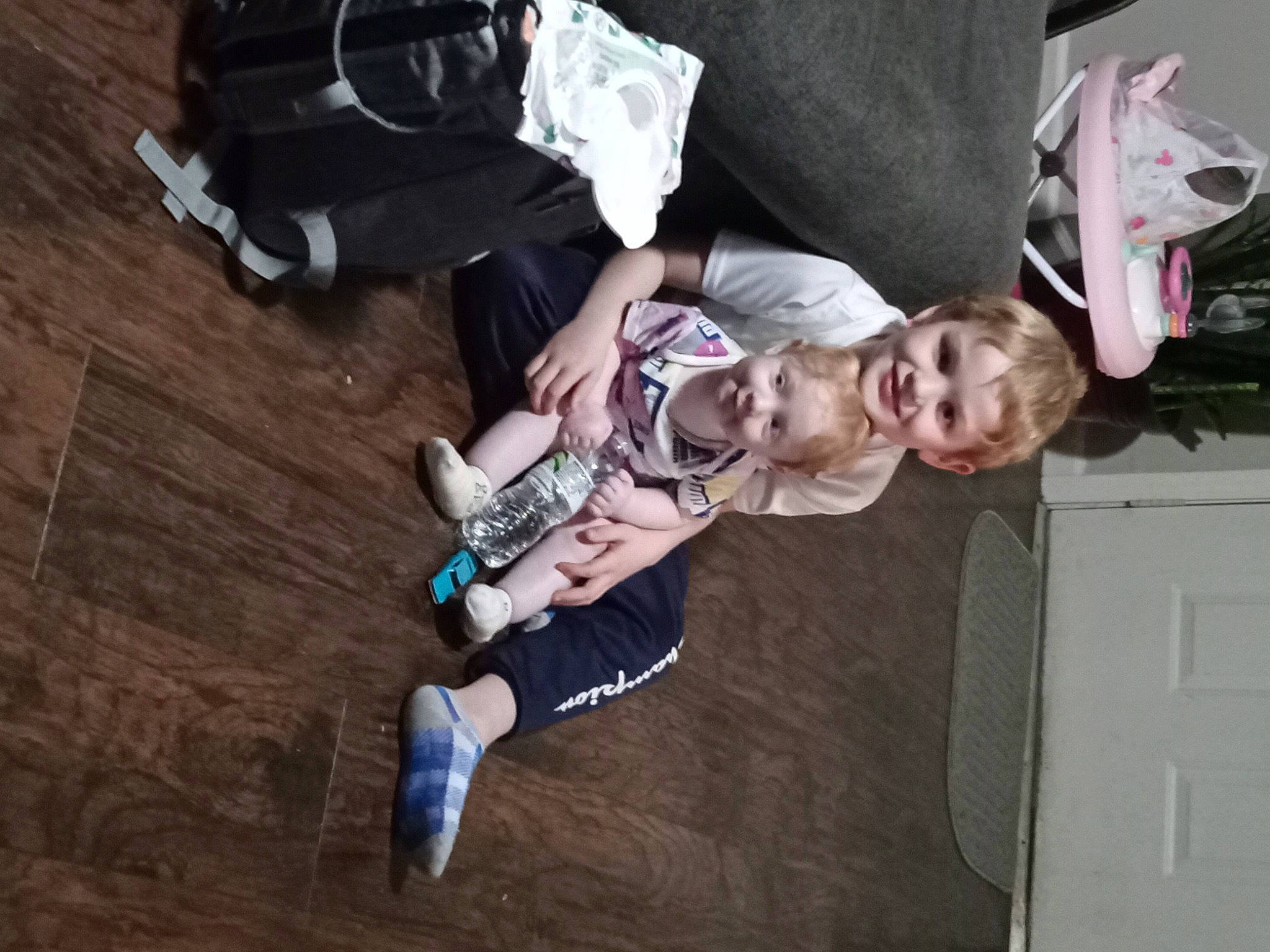 Leon is registered to the contest to win money with this photo: baby, baby_carriage, baby_products, baby_toddler_clothing, backpack, bag, child, door, flooring, fun, hardwood, joy, light_switch, luggage_and_bags, person, sitting, toddler, tree, wood