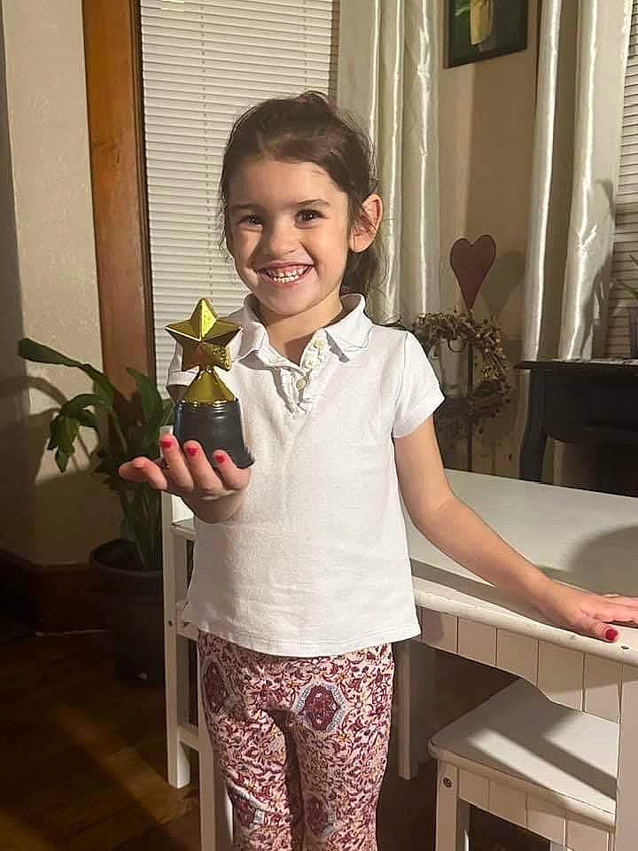 Avalynn joined the competition — help win amazing prizes! chair, child, door, event, fun, happy, houseplant, joy, pattern, person, plant, room, sitting, sleeve, smile, standing, t_shirt, thigh, toddler, trunk