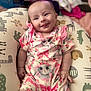 Sophia joined the competition — help win amazing prizes! baby, infant, smiling, onesie, bunny_print, cushion, patterned, soft, comfortable, indoors, skin, face, hand, happy, cute, child, clothing, relaxing, tongue_out, portrait