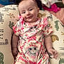 baby, infant, smile, cute, bunny_print, pink_clothing, cushion, animal_pattern, soft_focus, indoor, child, portrait, happy, relaxing, baby_girl, comfort, clothing, pattern, small_child, seated
