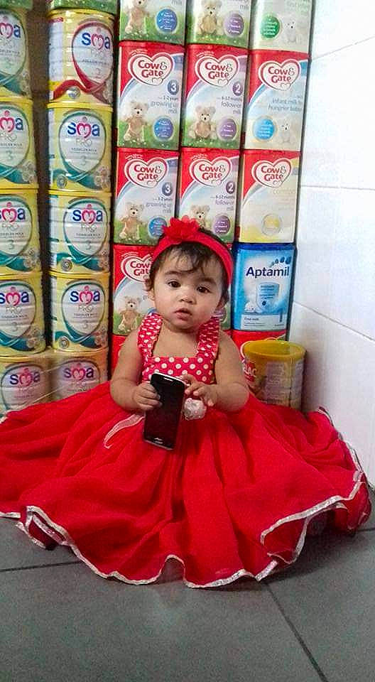 Chelsea Opingo Calsas is registered to the contest to win money with this photo: baby, baby_toddler_clothing, child, dress, event, eye, flooring, fun, happy, head, leisure, magenta, pattern, person, pink, room, sitting, skin, textile, toddler