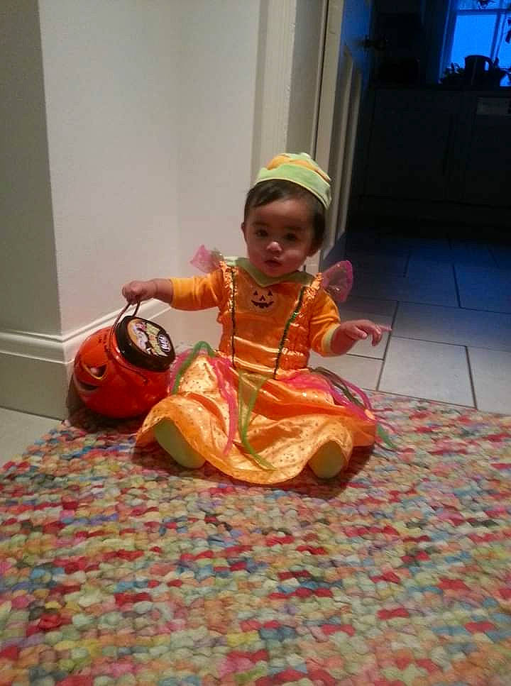 Chelsea Opingo Calsas is registered to the contest to win money with this photo: child, costume, dress, event, eye, flooring, fun, happy, human_leg, jewellery, leisure, musical_instrument, peach, person, room, sandal, sitting, toddler, tradition, vacation