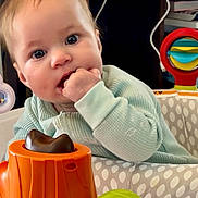Skye joined the competition — help win amazing prizes! baby, infant, child, face, hand, toy, activity_seat, indoor, cables, fan, playtime, curious, bright_eyes, clothing, closeup, furniture, colorful, plastic, expression, cute