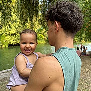 Naya a rejoint le concours — aidez-le/la à gagner de superbes lots ! baby, child, young_adult, river, water, trees, greenery, smile, happy, outdoor, nature, holding, person, sleeveless_shirt, curly_hair, grass, people, summer, park, daytime