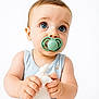 baby, blue_eyes, pacifier, onesie, soft_cloth, sailboat_print, cute, infant, child, portrait, close_up, hands, light_blue, white_background, sitting, adorable, looking_up, skin, expression, young