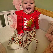 Amelia joined the competition — help win amazing prizes! baby, child, smiling, pajamas, headband, crib, teddy_bear, stuffed_animal, happy, indoors, clothing, red, patterned_pants, infant, cute, holiday, festive, portrait, sitting, toy