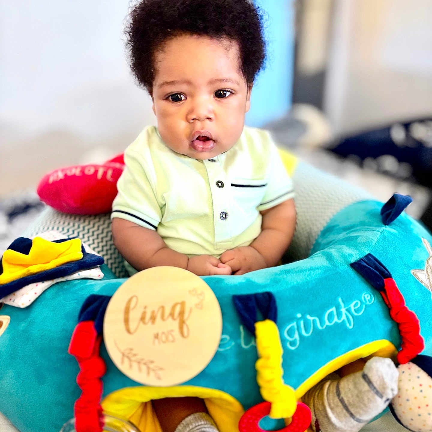 Jude-Ayden a rejoint le concours — aidez-le/la à gagner de superbes lots ! baby, child, closeup, clothing, colorful, comfort, curly_hair, cute, expression, fabric, happy, indoor, infant, pattern, play, portrait, seated, socks, soft_focus, toy