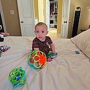 Ricky joined the competition — help win amazing prizes! toddler, child, bed, toy, ball, snack_bag, room, closet, door, blanket, pajamas, floor, furniture, indoor, curious, sitting, face, expression, playtime, home