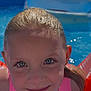 Nina participe au concours pour gagner de l'argent avec cette photo : child, smiling, close_up, blue_eyes, wet_hair, pool, water, floaties, swimming, summer, outdoor, sunny, fun, playful, face, person, swimsuit, recreation, childhood, happy