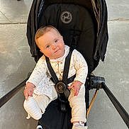 Alba a rejoint le concours — aidez-le/la à gagner de superbes lots ! baby, stroller, infant, child, cute, seatbelt, footwear, sneakers, indoor, person, clothing, curious, floor, legs, black, white, casual, expression, hands, head