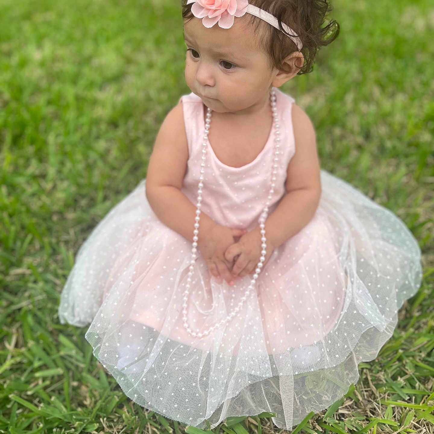 Evelyn is registered to the contest to win money with this photo: accessories, backyard, child, clothing, dress, face, female, formalwear, girl, grass, head, jewelry, lawn, nature, necklace, person, photography, plant, portrait, sitting