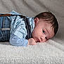 baby, infant, child, denim, overalls, blue_shirt, lying_down, blanket, soft_texture, portrait, cute, face, eyes, hair, indoors, young_child, cozy, clothing, skin, toddler