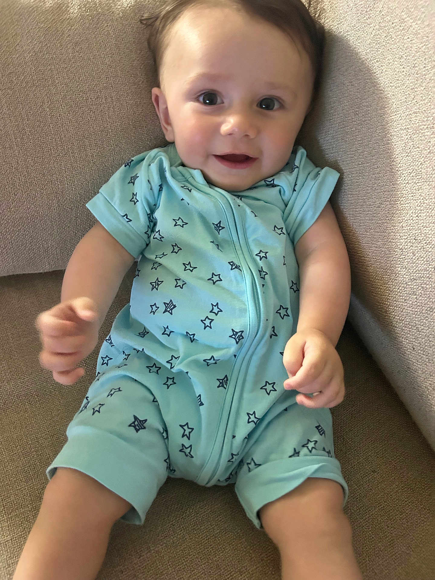 Cyriak participe au concours pour gagner de l'argent avec cette photo : baby, child, infant, onesie, blue_clothing, stars_pattern, couch, sofa, smile, happy, face, eyes, arms, legs, skin, indoor, comfortable, relaxed, young_child, portrait