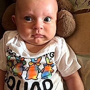Finnegan is registered to the contest to win money with this photo: baby, infant, tshirt, plush_toy, stuffed_animal, sitting, wide_eyes, expression, indoor, face, person, child, cute, clothing, soft_toy, colorful, closeup, portrait, skin, young