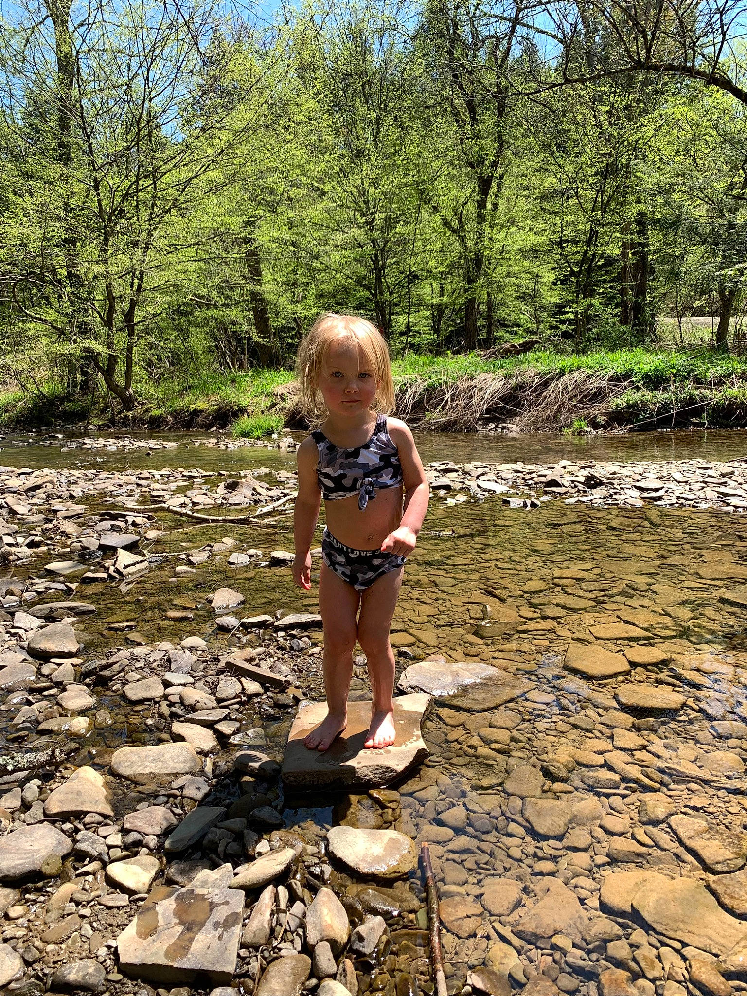 Rebel joined the competition — help win amazing prizes! bank, bedrock, biome, botany, fluvial_landforms_of_streams, grass, leisure, natural_environment, natural_landscape, people_in_nature, person, plant, riparian_zone, shorts, sky, toddler, tree, vegetation, water, water_resources