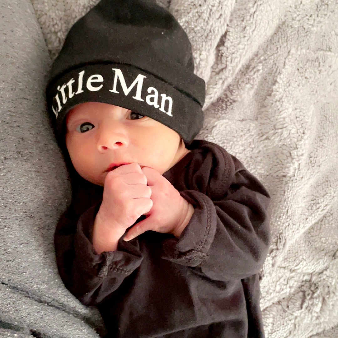 Joseph is registered to the contest to win money with this photo: baby, beanie, bodypart, bonnet, cap, clothing, face, finger, hand, hat, head, hood, hoodie, knitwear, newborn, person, photography, portrait, sweater, sweatshirt