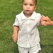 Leander joined the competition — help win amazing prizes! toddler, child, white_clothing, shorts, shirt, holding_hand, grass, outdoor, daylight, young_child, standing, baby, person, cute, summer, nature, skin, portrait, curious, hand