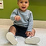 Leander is registered to the contest to win money with this photo: toddler, child, smiling, sitting, gray_sweater, black_shorts, white_shoes, indoor, green_wall, countertop, happy, cute, young, person, portrait, casual_clothing, short_hair, playful, baby, feet