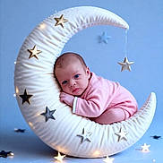 Ashley a rejoint le concours — aidez-le/la à gagner de superbes lots ! baby, blue_background, calm, child, cozy, crescent_moon, cute, decorative_pillow, glowing_lights, indoor, infant, newborn, pink_clothing, portrait, resting, sleepy, soft_lighting, soft_texture, star_decorations, studio_shot