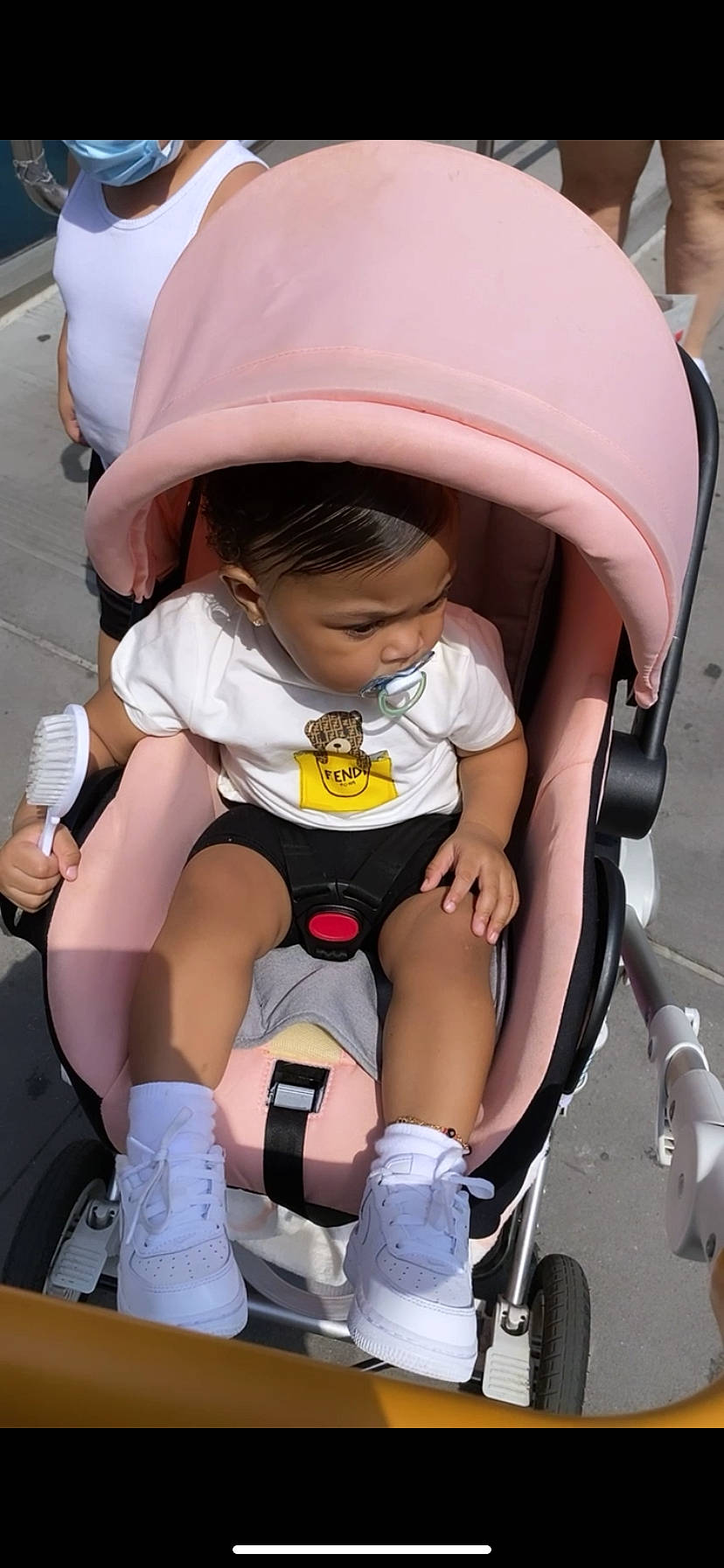 Madisyn is registered to the contest to win money with this photo: baby, baby_carriage, baby_toddler_clothing, child, comfort, face, human_leg, joint, knee, lap, leg, person, pink, shoe, skin, sneakers, thigh, tire, toddler, wheel