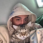 Mavin joined the competition — help win amazing prizes! person, cat, hoodie, tabby_cat, face, eyes, furry, pet, cozy, indoor, snuggling, close_up, sleeping_cat, comfort, blurred_background, casual_clothing, animal, warm, cute, relaxed