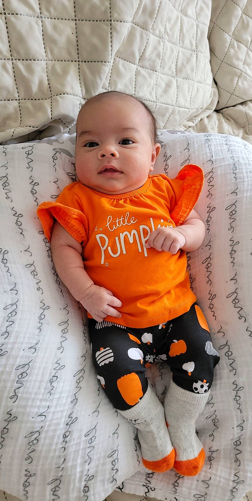 Emy is registered to the contest to win money with this photo: baby, baby_toddler_clothing, cheek, comfort, eye, face, finger, happy, head, human_body, neck, orange, person, product, skin, sleeve, stomach, t_shirt, textile, thigh