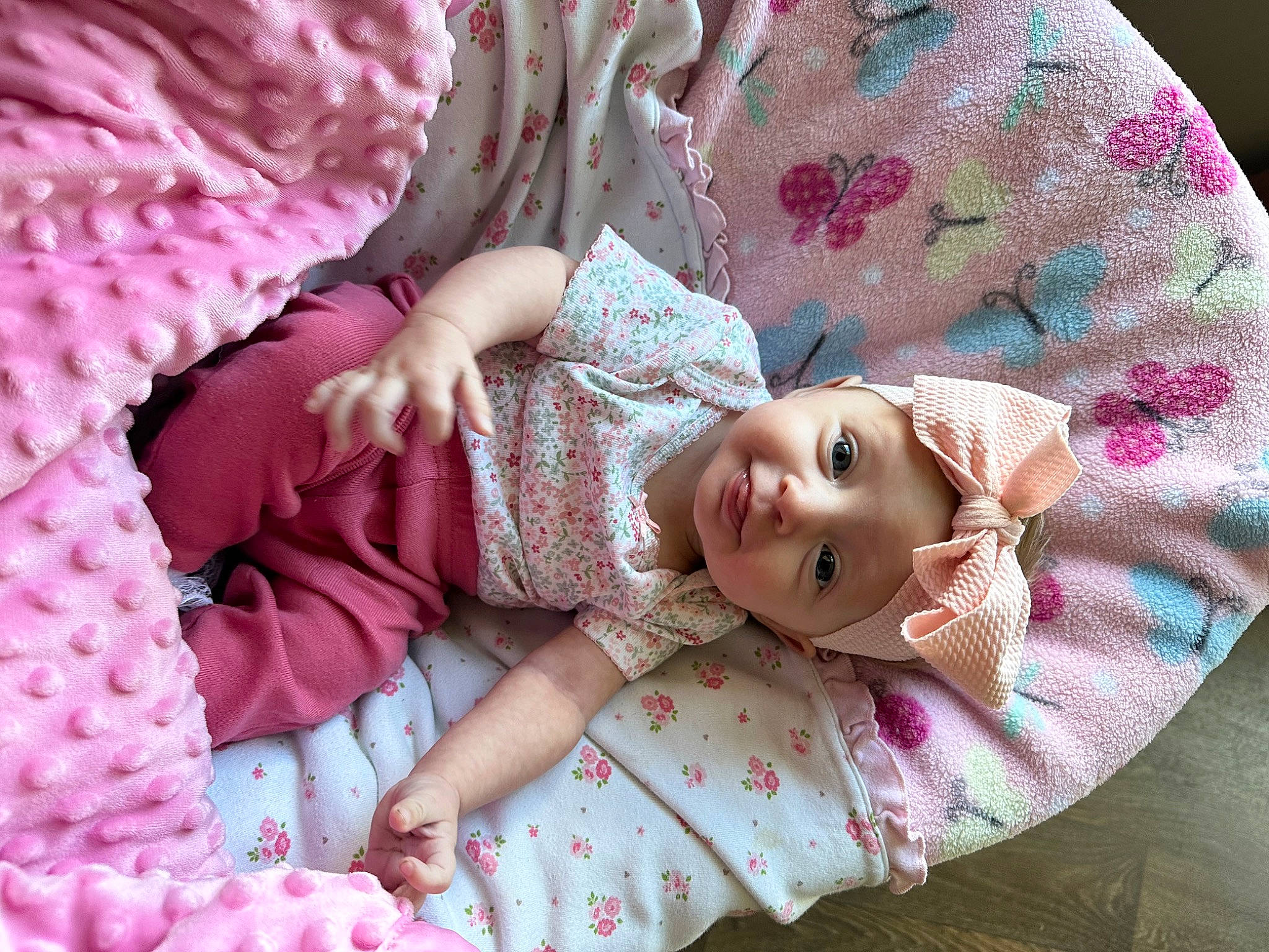 Berlin is registered to the contest to win money with this photo: baby_toddler_clothing, child, comfort, dress, eye, eyelash, hand, head, headwear, linens, lip, magenta, mammal, pattern, person, petal, pink, skin, sleeve, textile