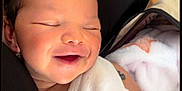 Eliana a rejoint le concours — aidez-le/la à gagner de superbes lots ! baby, infant, smile, sleeping, white_clothing, arms, tattoo, blanket, cozy, closeup, person, cute, newborn, resting, indoor, soft_light, peaceful, love, heart_doodle, warmth