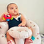 baby, infant, toy, rattle, inflatable_chair, child, sitting, cute, indoor, comfort, foot, hand, black_clothing, pattern, wall, face, expression, relaxing, skin, young