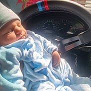 émile a rejoint le concours — aidez-le/la à gagner de superbes lots ! baby, sleeping, blue_clothing, car_interior, steering_wheel, graffiti, urban, child, person, seat, window, hand, headwear, soft_texture, relaxation, daylight, portrait, candid, infant, cozy