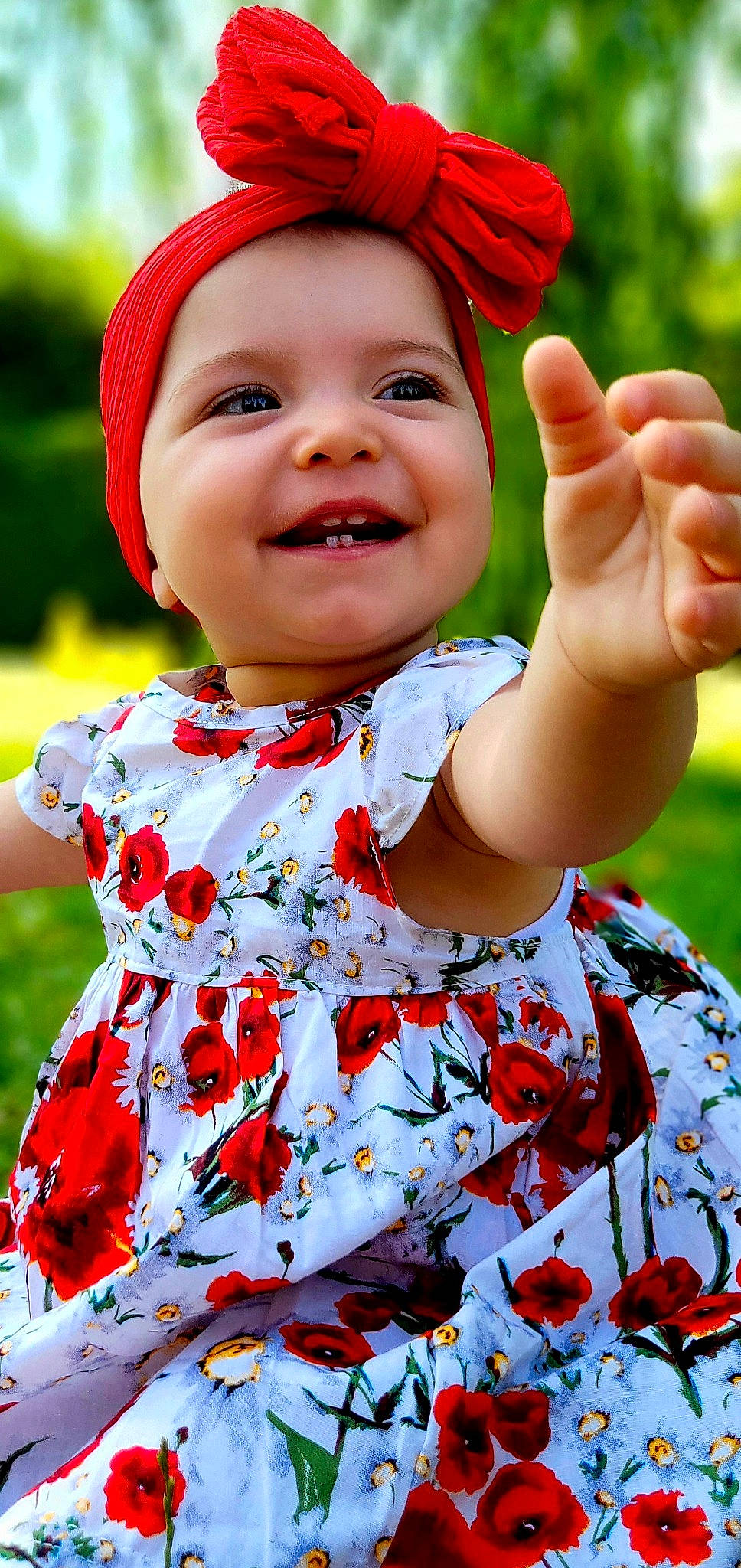 Luna participe au concours pour gagner de l'argent avec cette photo : baby_laughing, baby_toddler_clothing, child, dress, face, facial_expression, finger, gesture, hand, happy, head, headwear, joy, people_in_nature, person, photograph, pink, red, skin, sleeve