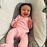 Aria is registered to the contest to win money with this photo: baby, infant, smiling, pink_clothing, onesie, baby_seat, cushion, happy, portrait, indoor, toddler, child, cute, person, face, hair, seat, fabric, comfort, relaxing