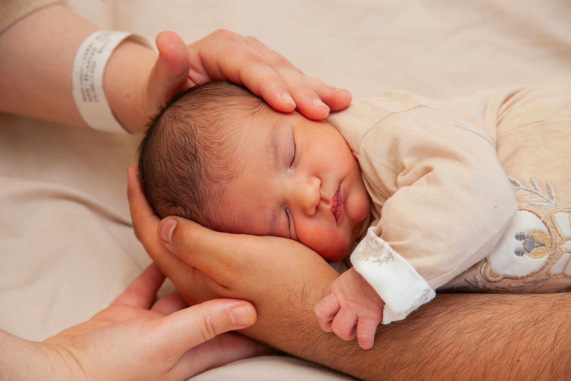 Sirat participe au concours pour gagner de l'argent avec cette photo : newborn, baby, sleeping, hands, adult_hands, cradling, close_up, skin, infant, peaceful, beige, soft_lighting, portrait, family, tenderness, comfort, clothing, bed, resting, caring