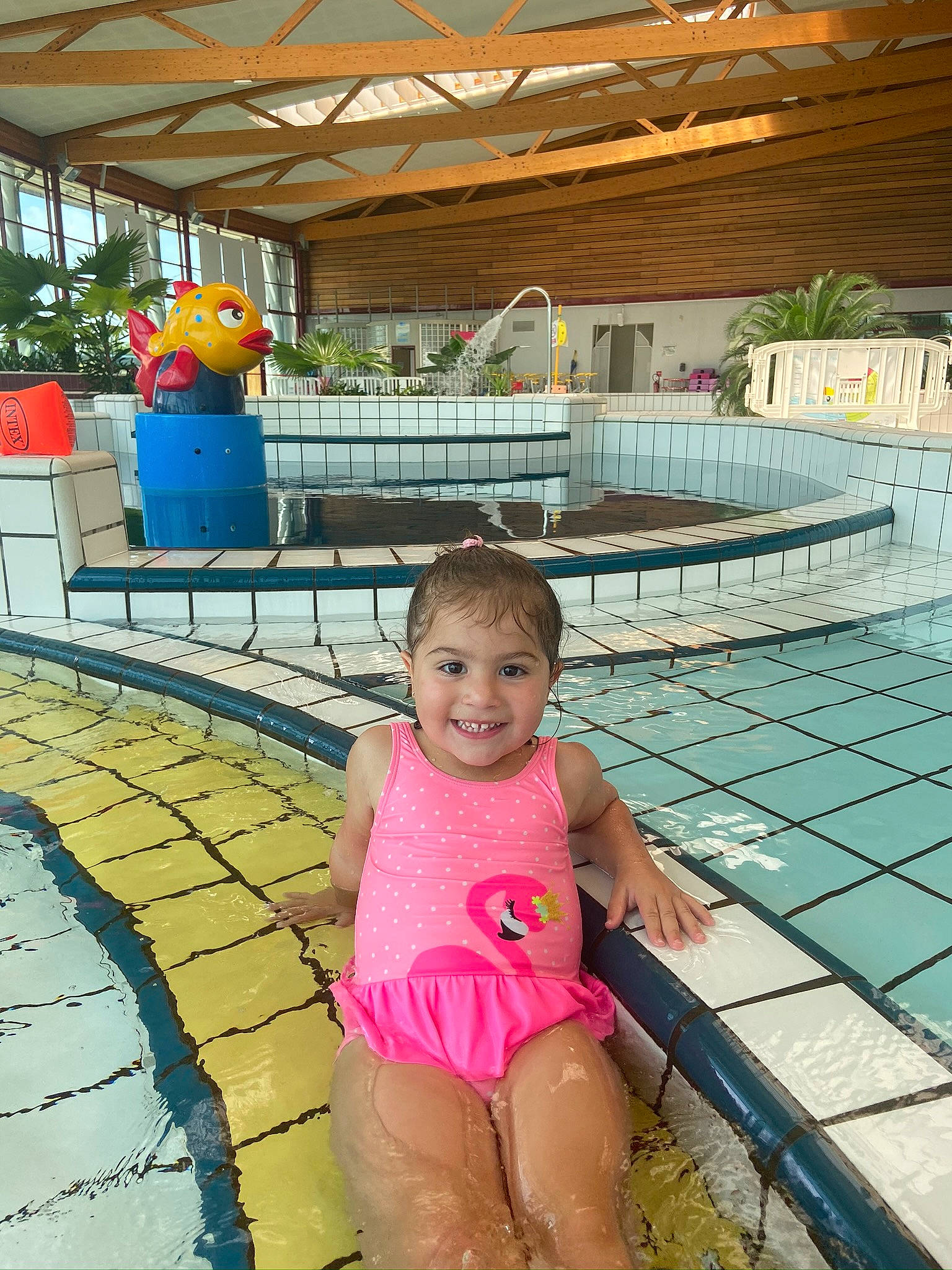 Noor a rejoint le concours — aidez-le/la à gagner de superbes lots ! baby_toddler_clothing, chair, fun, green, happy, human_leg, joy, leisure, magenta, person, play, recreation, sitting, smile, swimming_pool, thigh, toddler, travel, vacation, vertebrate