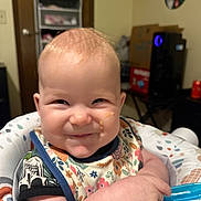 Everleigh joined the competition — help win amazing prizes! baby, child, smiling, food, bib, spoon, highchair, indoor, person, face, infant, cute, cheeky, baby_seat, patterned_clothing, happy, home, furniture, feeding, playful