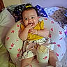 Evanaley joined the competition — help win amazing prizes! baby, child, infant, smiling, happy, portrait, sitting, indoor, bedroom, baby_seat, cushion, blanket, bottle, yellow_shirt, floral_clothing, headband, dark_hair, finger_in_mouth, nursery, cozy