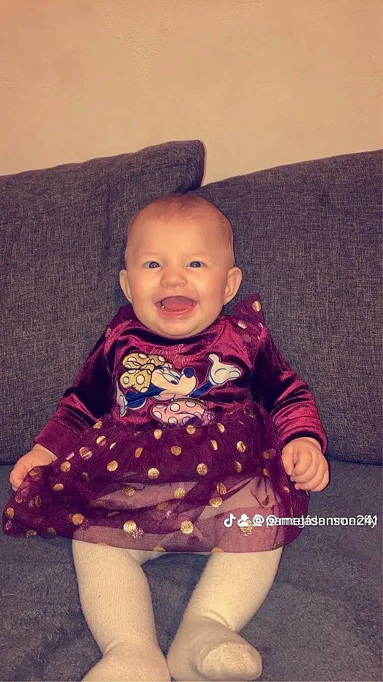 Mya participe au concours pour gagner de l'argent avec cette photo : arm, baby, baby_toddler_clothing, cheek, comfort, cool, floor, iris, magenta, neck, outerwear, person, pink, purple, skin, sleeve, smile, standing, textile, toddler