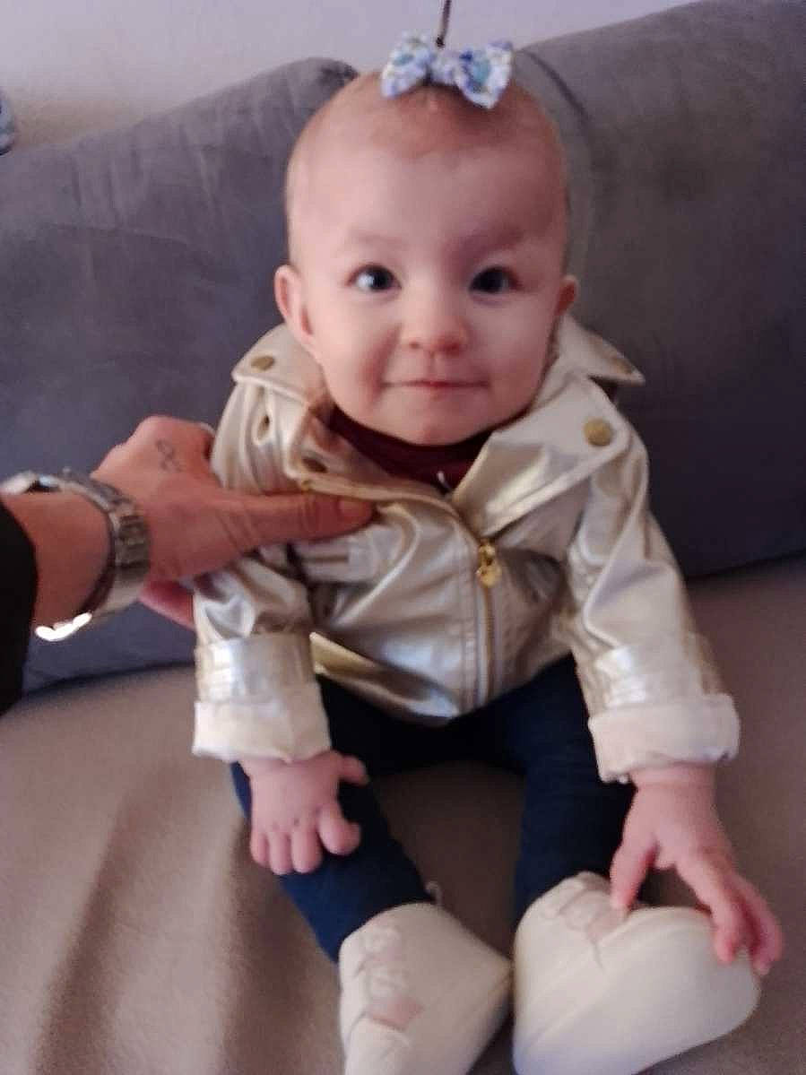 Mya a rejoint le concours — aidez-le/la à gagner de superbes lots ! baby, baby_toddler_clothing, cheek, chin, comfort, eye, finger, gesture, head, human_body, iris, neck, person, pink, skin, sleeve, smile, thumb, toddler, watch