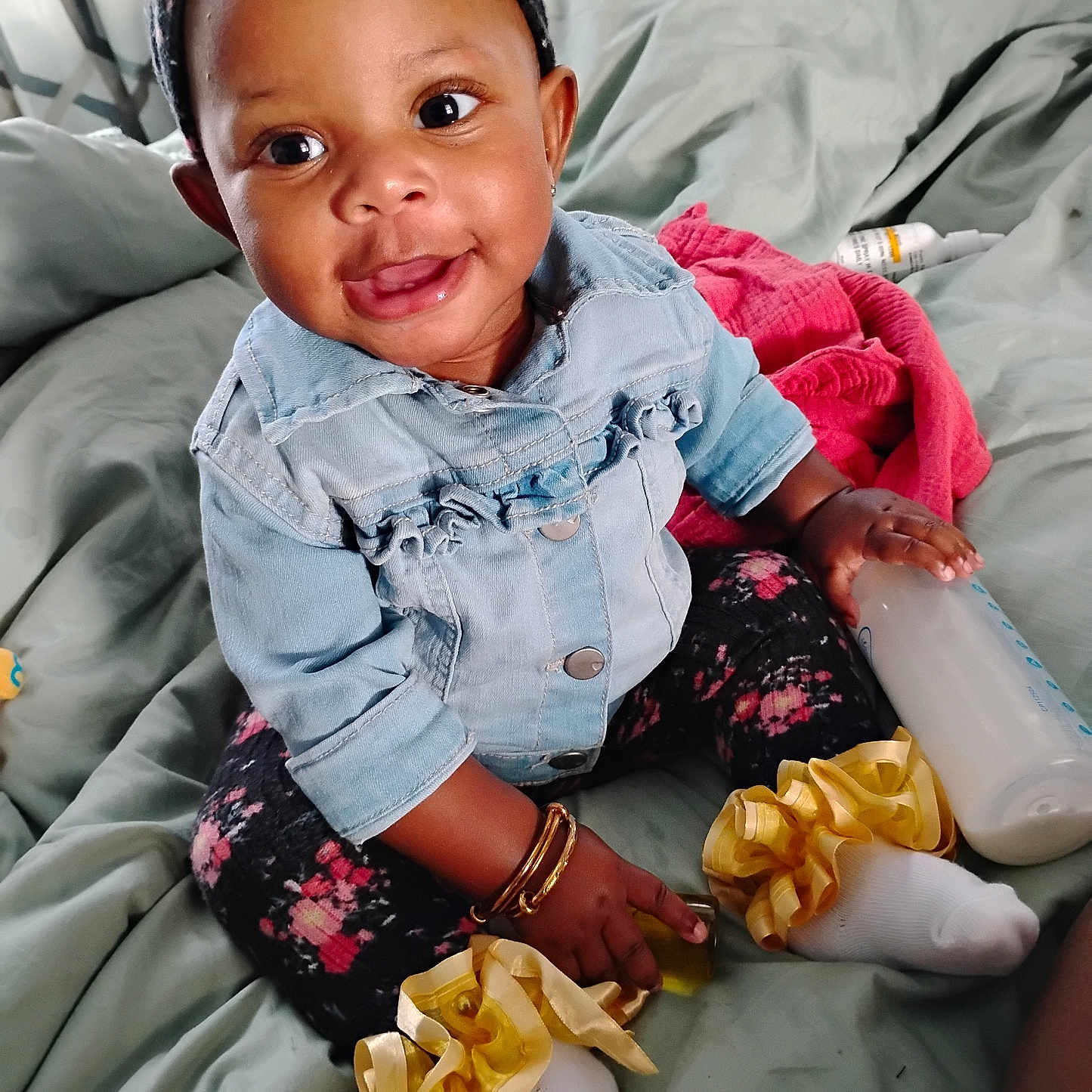 Nevaeh joined the competition — help win amazing prizes! baby, child, smiling, denim_jacket, floral_leggings, yellow_ribbons, socks, bottle, bed, blanket, pillow, indoor, cute, happy, person, headband, bracelet, infant, portrait, toddler