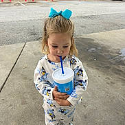Harley is registered to the contest to win money with this photo: blue_bow, casual, child, clothing, concrete, cup, cute, daylight, drink, footwear, girl, outdoor, pajamas, parking_lot, person, red_posts, sidewalk, store, straw, van