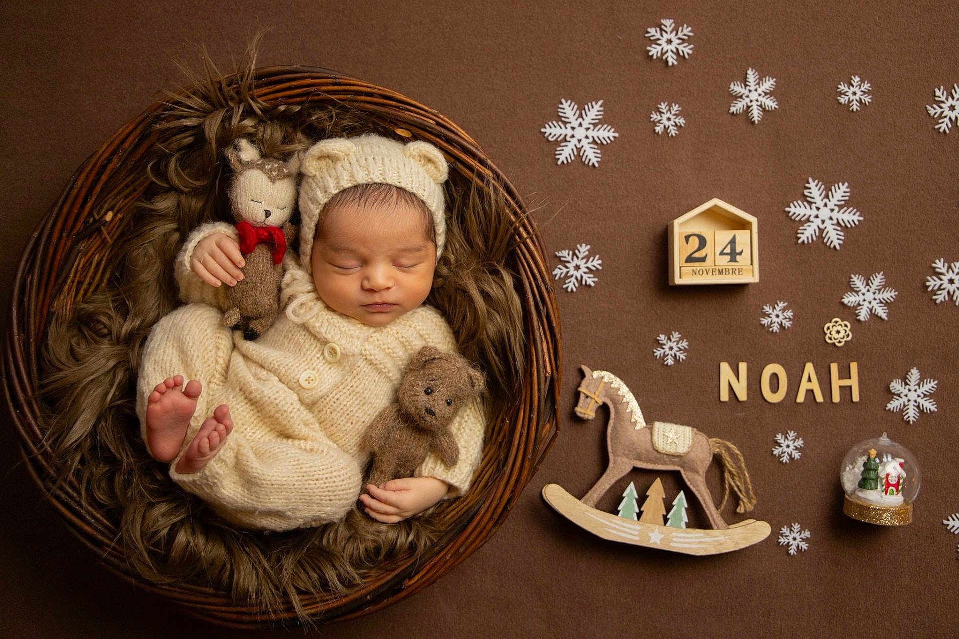 Noah Ceto a rejoint le concours — aidez-le/la à gagner de superbes lots ! newborn, baby, sleeping, knitted_outfit, basket, fur, stuffed_animals, bear_ears, snowflakes, wooden_letters, rocking_horse, snow_globe, calendar_block, brown_background, cozy, winter_theme, cute, portrait, infant, decor