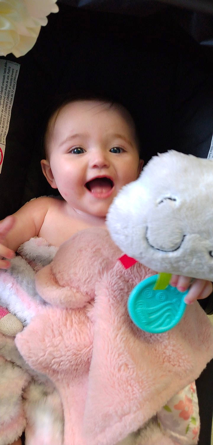 Lorraine is registered to the contest to win money with this photo: baby_toddler_clothing, cheek, eye, facial_expression, finger, gesture, happy, head, interaction, iris, lip, mammal, mouth, nose, person, pink, product, skin, smile, toy