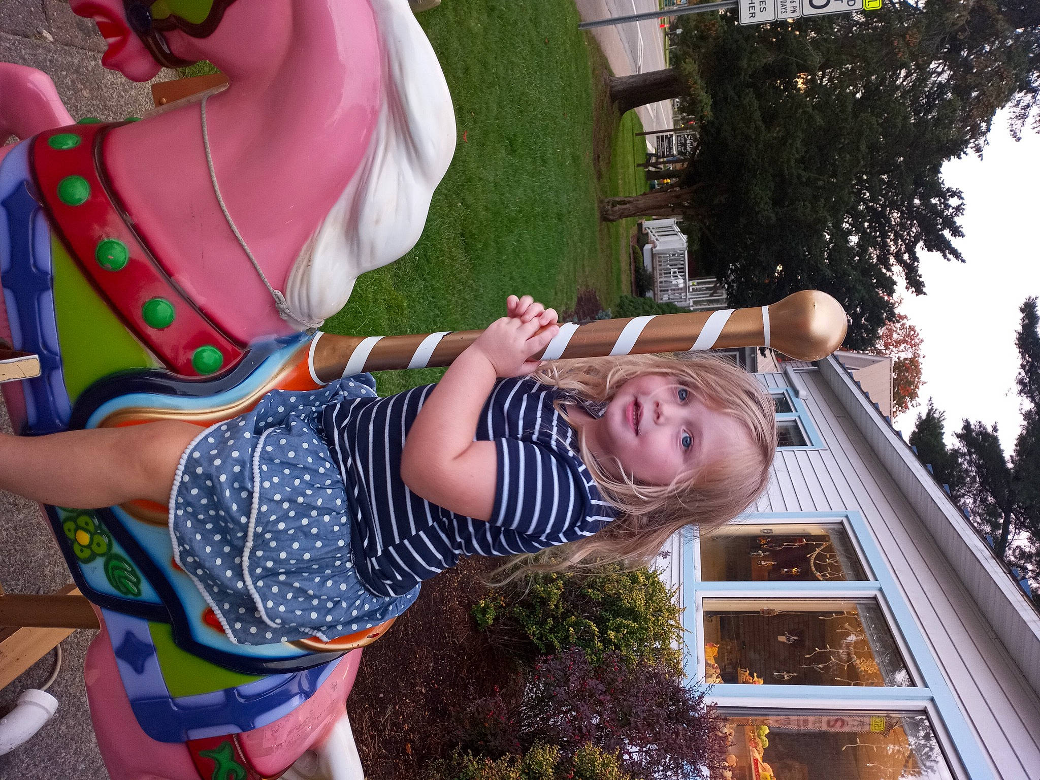 Aubrey is registered to the contest to win money with this photo: arm, child, fun, grass, green, hairstyle, happy, human_leg, leisure, people_in_nature, person, pink, plant, public_space, sandal, summer, thigh, toy, tree, trunk