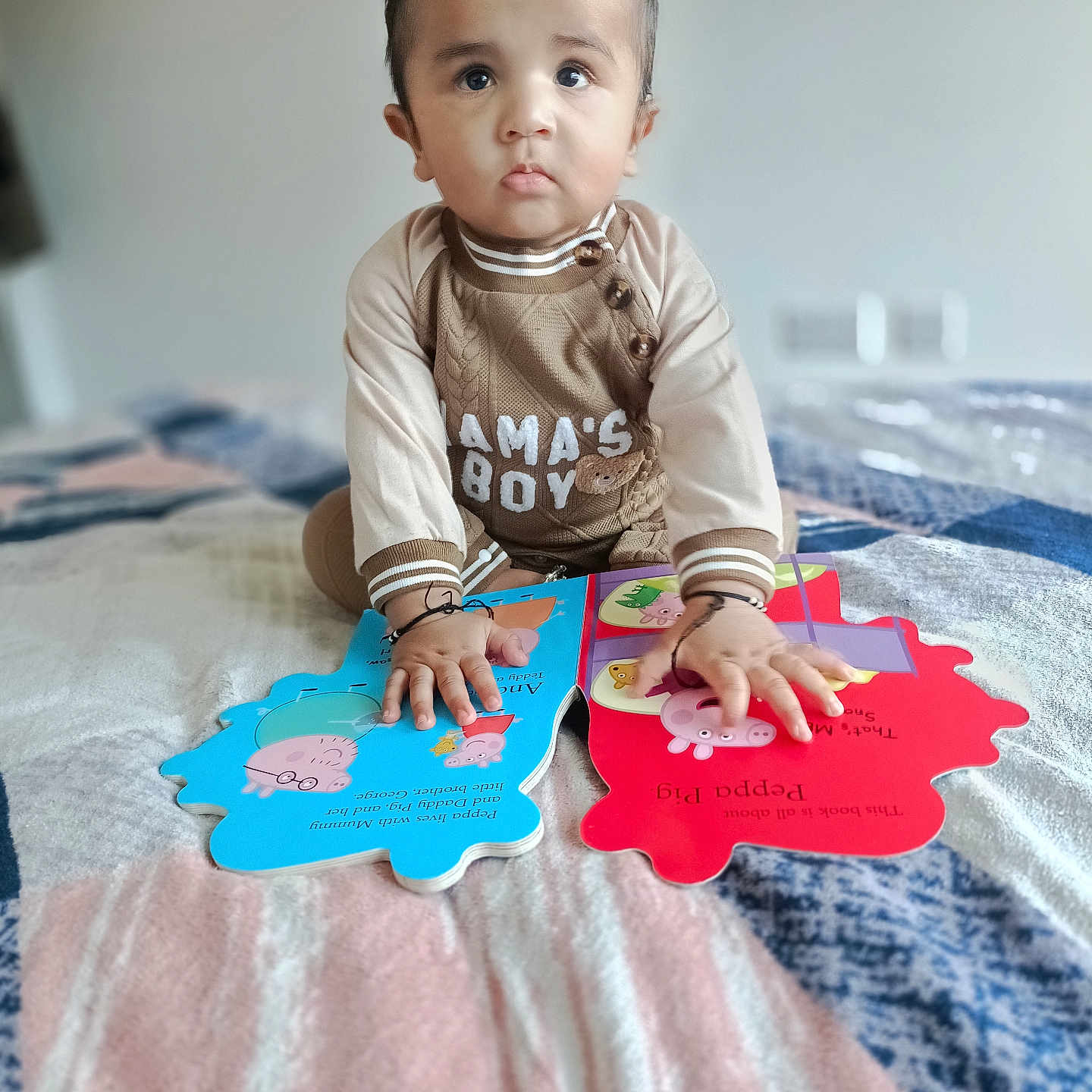 Gurfateh Singh joined the competition — help win amazing prizes! baby, bed, blanket, book, child, clothing, curious, cute, expression, face, hands, indoors, peppa_pig, portrait, reading, sitting, soft_focus, storybook, toddler, young_child