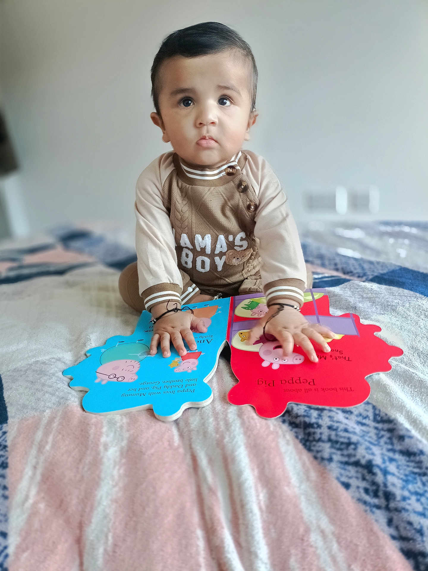 Gurfateh Singh joined the competition — help win amazing prizes! toddler, child, baby, book, reading, bed, blanket, indoors, cute, face, hands, clothing, expression, curious, peppa_pig, storybook, sitting, soft_focus, portrait, young_child
