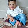 Gurfateh Singh joined the competition — help win amazing prizes! baby, child, smiling, happy, jeans, white_shirt, barefoot, indoor, couch, blanket, patterned, infant, portrait, cute, relaxed, human, sitting, black_hair, small_hand, toes