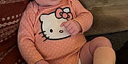 Daniela is registered to the contest to win money with this photo: baby, infant, child, pink_headband, hello_kitty, onesie, socks, bambino, couch, cushion, patterned_fabric, smiling, sitting, indoors, cute, portrait, person, apparel, headwear, cozy