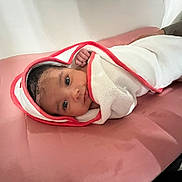 Kariah joined the competition — help win amazing prizes! baby, blanket, comfort, cute, eyes, face, hand, indoors, infant, lying_down, newborn, person, pink_cushion, portrait, relaxed, resting, skin, soft, towel, wrapped